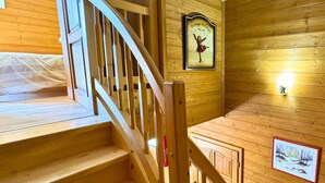 A wooden staircase with a handrail, wooden walls, and a framed picture of a dancer. - Z-Chalet Mitoyen 6A., Z-Chalet Mitoyen 6A. (Mont-Saxonnex)