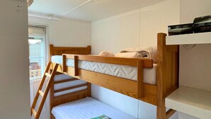 A bunk bed room with a ladder, a small table, and a window. - Spacious mobile home + terrace !, Spacious mobile home + terrace ! (Verchaix)
