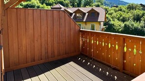 A wooden deck with a view of a mountain and a house. - Z-Chalet Mitoyen 5A., Z-Chalet Mitoyen 5A. (Mont-Saxonnex)
