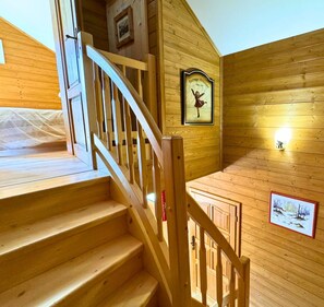 Staircase leads to an upper level with a handrail and framed artwork.