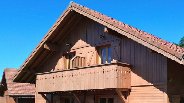 A wooden house with a balcony, a wooden deck, and a small garden area. - Z-Chalet Mitoyen 5A., Z-Chalet Mitoyen 5A. (Mont-Saxonnex)