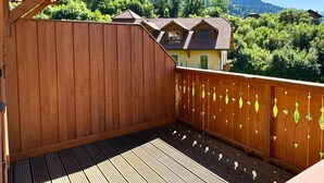 A wooden deck with a view of a mountain and a house. - Z-Chalet Mitoyen 2B., Z-Chalet Mitoyen 2B. (Mont-Saxonnex)