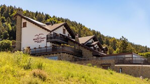 A hotel with a stone facade, multiple balconies, and a mountainous backdrop. - Hotel Monte Campo Ristorante Santa Lucia (Capracotta)