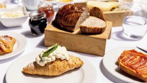 A breakfast setting with croissants, bread, and various spreads on plates. - Hotel Monte Campo Ristorante Santa Lucia (Capracotta)
