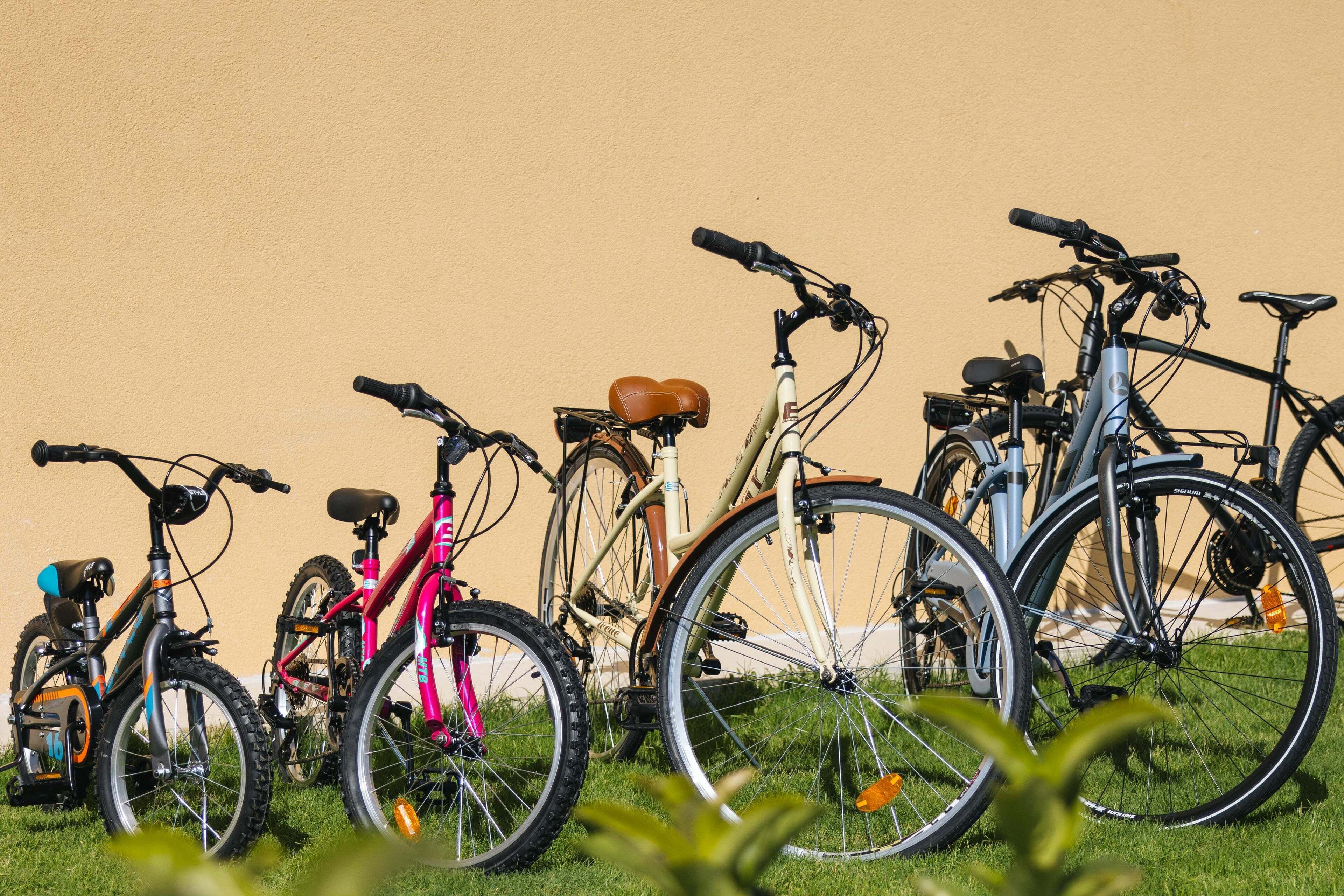 A row of bicycles parked against a wall.
