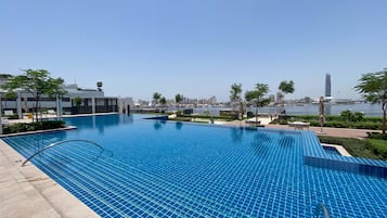 Alberca al aire libre, sombrillas en la alberca y camastros