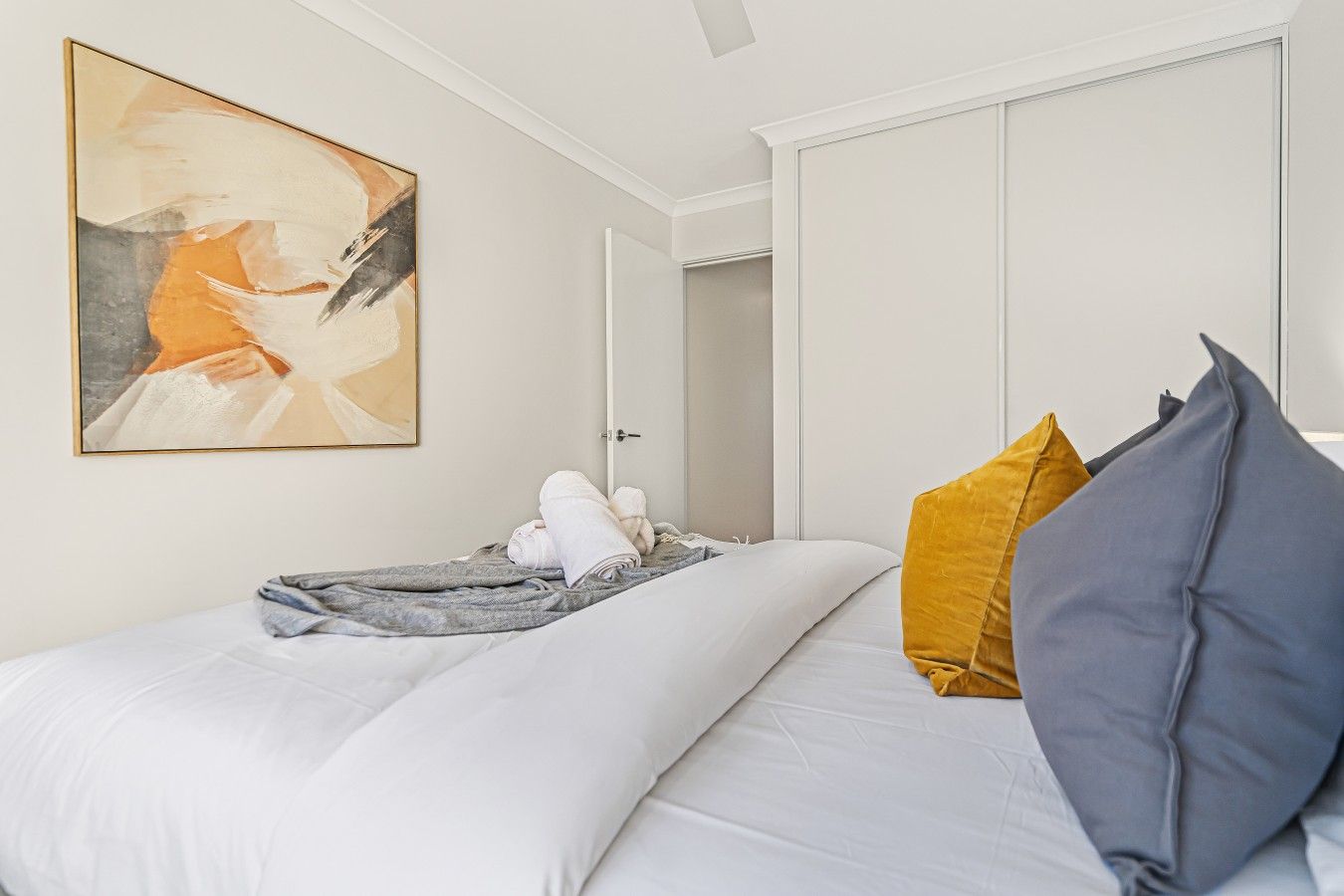 Una habitació d'hotel amb un llit, un quadre i un armari.