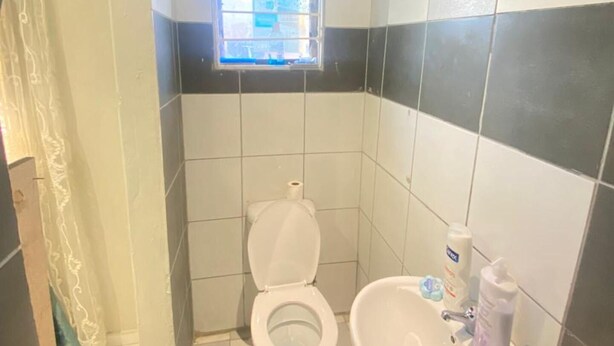 Un baño con inodoro, lavamanos y ventana.