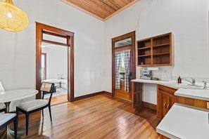 Una cocina moderna con armarios de madera, encimera blanca y pileta integrada.