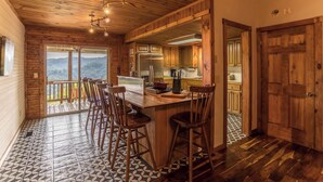 A wooden interior with a bar area, kitchen, and a view through the door. - Grandview Getaway (Deep Gap)