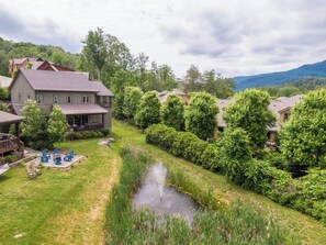 A residential area with houses, a pond, and a grassy lawn. - Natures Blessings at Elk Creek (Banner Elk)