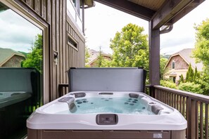 A hot tub on a wooden deck with a view of houses and trees. - Natures Blessings at Elk Creek (Banner Elk)