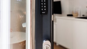 A modern door with a numeric keypad and a key lock. - BOHO Studio - Augarten City Apartment (Vienna)