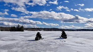 A snow-covered field with two snowmobiles and a clear blue sky. - Bear`s Den *ATV Access*Walk to Town/Bars/Restaurants*A/C*Pet Friendly (Greenville)