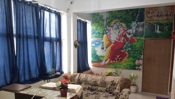 Een woonkamer met een bank, een marmeren tafel en een groot schilderij aan de muur.