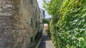 A narrow alleyway flanked by stone buildings, one with a staircase leading to a balcony. - Emma House, Terrace and Sea View, Moneglia (Moneglia)