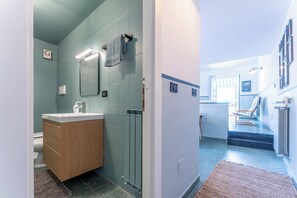 A modern bathroom with a wooden vanity, a glass shower enclosure, and a towel hanging on a rack. - Emma House, Terrace and Sea View, Moneglia (Moneglia)