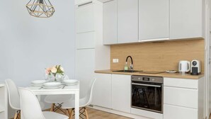 A modern kitchen with white cabinets, a wooden countertop, and a built-in oven.
