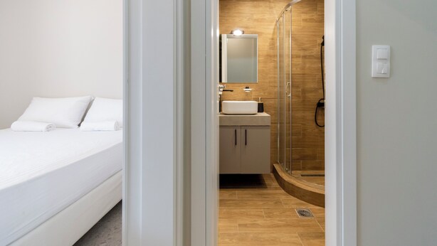 A modern bathroom with a glass shower enclosure, a sink, and a mirror. - SithoniaRS Seashell Maisonette (Νικήτη)