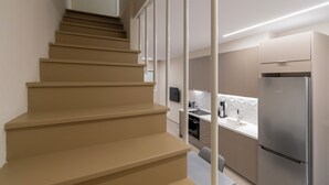 A modern kitchen with a stainless steel refrigerator, a built-in oven, and a white countertop. - SithoniaRS Seashell Maisonette (Νικήτη)