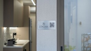 A sign with the name "SITHONIA" and a QR code, indicating a premium and luxury reservation service. - SithoniaRS Seashell Maisonette (Νικήτη)