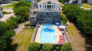A large house with a swimming pool, a covered deck, and a well-maintained lawn. - Private pool/spa, rooftop deck, 5min walk to beach (Corolla)