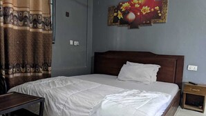 Ein Einzelbett mit weißer Daunendecke, einem hölzernen Kopfteil, einem Nachttisch und einer Wand mit Blumenmotiv.
