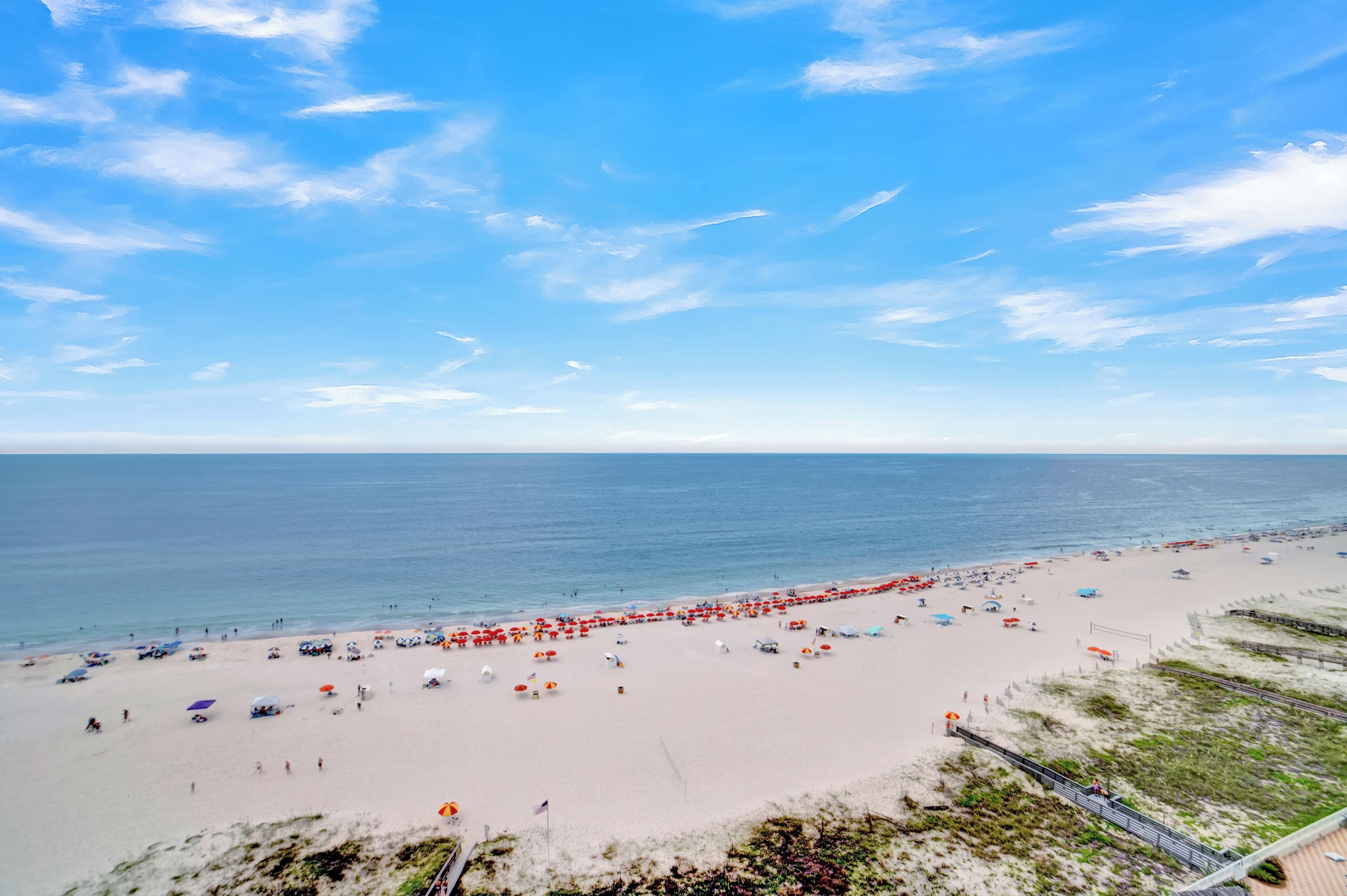 Une plage avec des parasols et des gens.