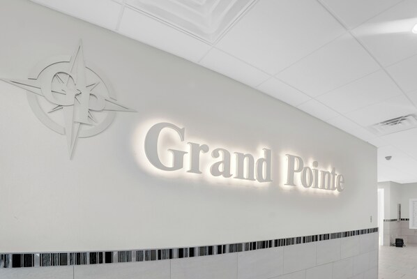 A hotel sign with a compass design and the name "Grand Pointe".