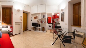 A compact living space with a kitchenette, a dining area, and a small seating area. - Navona Romantic House (Roma)