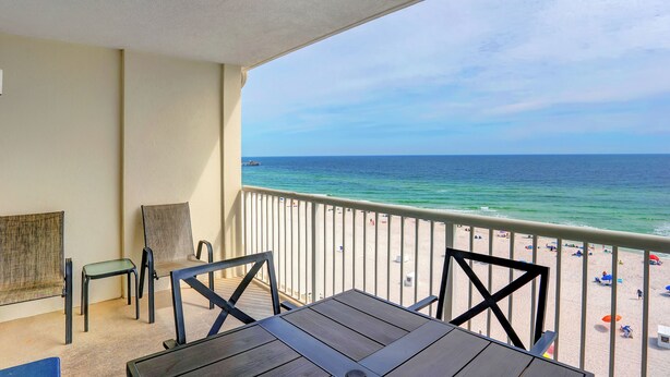 Ein Balkon mit Blick auf Strand und Meer.