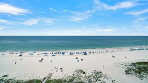 Ein Strand mit weißem Sand, blauem Himmel und ruhiger See.