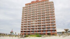 Ein mehrstöckiges Hotel mit Balkonen direkt am Strand.