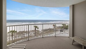 Ein Balkon mit Blick auf Strand und Meer.