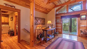A wooden cabin interior with a kitchen, a dining area with a table and chairs, and a large sliding glass door leading to a deck. - A Moon River View (Boone)