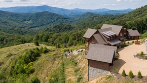 Un chalet comprenant plusieurs cabanes en bois, situé dans une région montagneuse offrant une vue panoramique sur les environs.