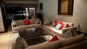 Ein Wohnzimmer mit zwei Sofas, einem Couchtisch und einem dekorativen Gegenstand auf einem Beistelltisch.