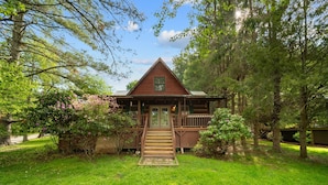 A wooden cabin with a front porch and a staircase leading to the entrance. - Bridgepoint Cabin (Vilas)