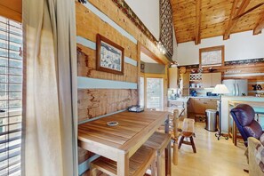 A wooden interior with a dining area, kitchen, and seating. - Napping Bear Cabin (Boone)