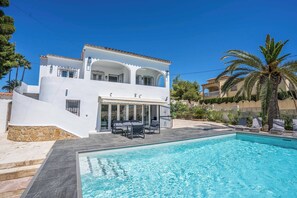 A two-story white villa with a swimming pool, outdoor seating, and a view of the surrounding landscape. - Villa Luxe (Calpe)
