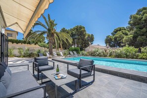 A poolside area with outdoor seating and a swimming pool. - Villa Luxe (Calpe)