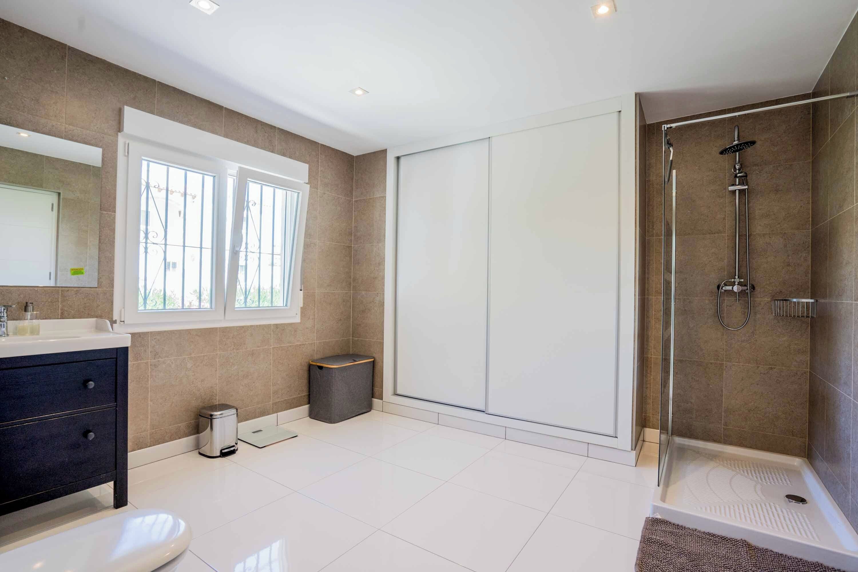 Un baño moderno con ducha, inodoro y tocador.