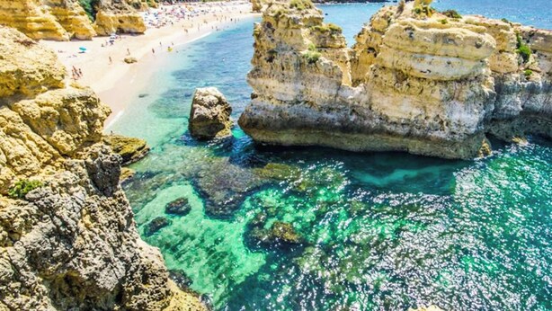 A coastal beach with clear turquoise waters, rocky formations, and a sandy shore. - Villa Julieta (Albufeira)
