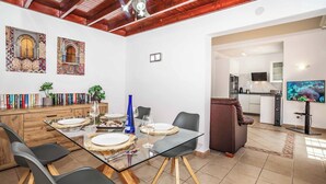A modern dining area with a glass table, black chairs, and a ceiling fan. - Villa Emilia (Yaiza)