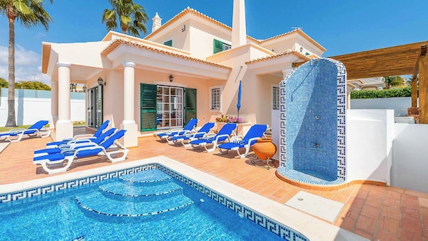 A pool area with lounge chairs and a tiled hot tub. - Villa Minerva (Albufeira)