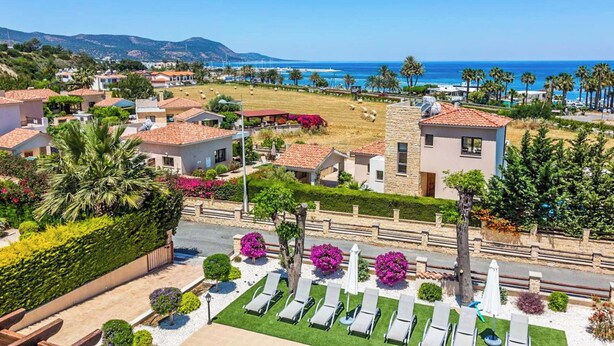 A coastal residential area with houses, a beach, and a clear view of the sea. - Villa Lara Latchi (Polis)