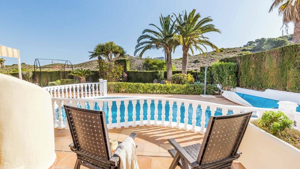 A poolside area with two chairs and a swing set, surrounded by lush greenery and a clear blue sky. - Villa Las Brisas 87 (Cartagena)