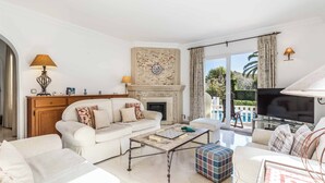 A living room with a fireplace, sofas, a coffee table, and a television. - Villa Las Brisas 87 (Cartagena)