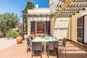 An outdoor patio with a table and chairs, a large vase, and a pergola structure. - Villa Las Brisas 86 (Cartagena)