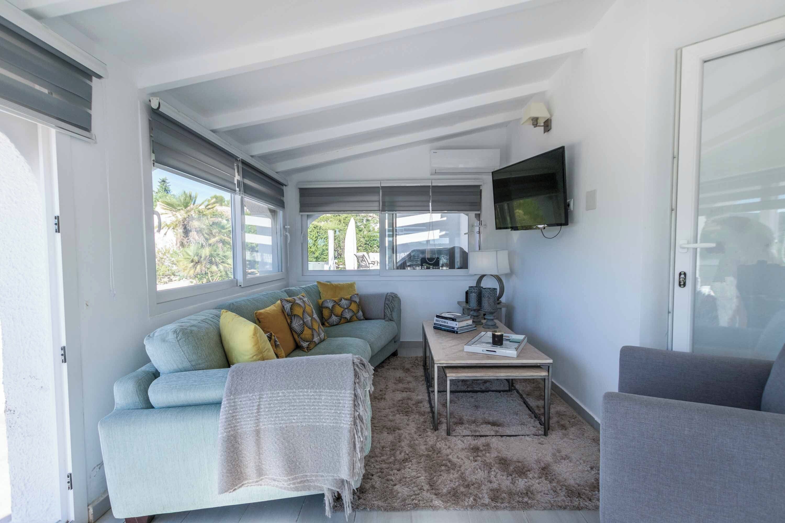 A cozy living room with a sofa, a coffee table, and a television.